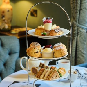 Afternoon tea stand laid out on a table with a selection of desserts and sandwiches