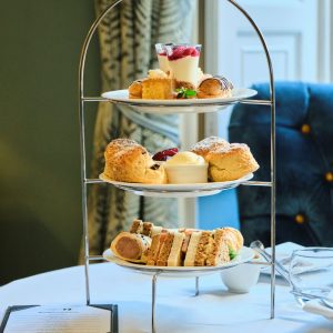 Afternoon teas stand with a selection of home made cakes and sandwiches set out on a table