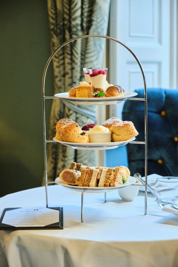 Afternoon teas stand with a selection of home made cakes and sandwiches set out on a table