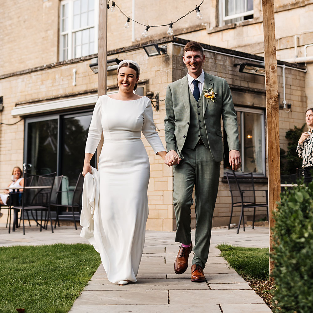 Issie and Chris walking hand in hand at their wedding