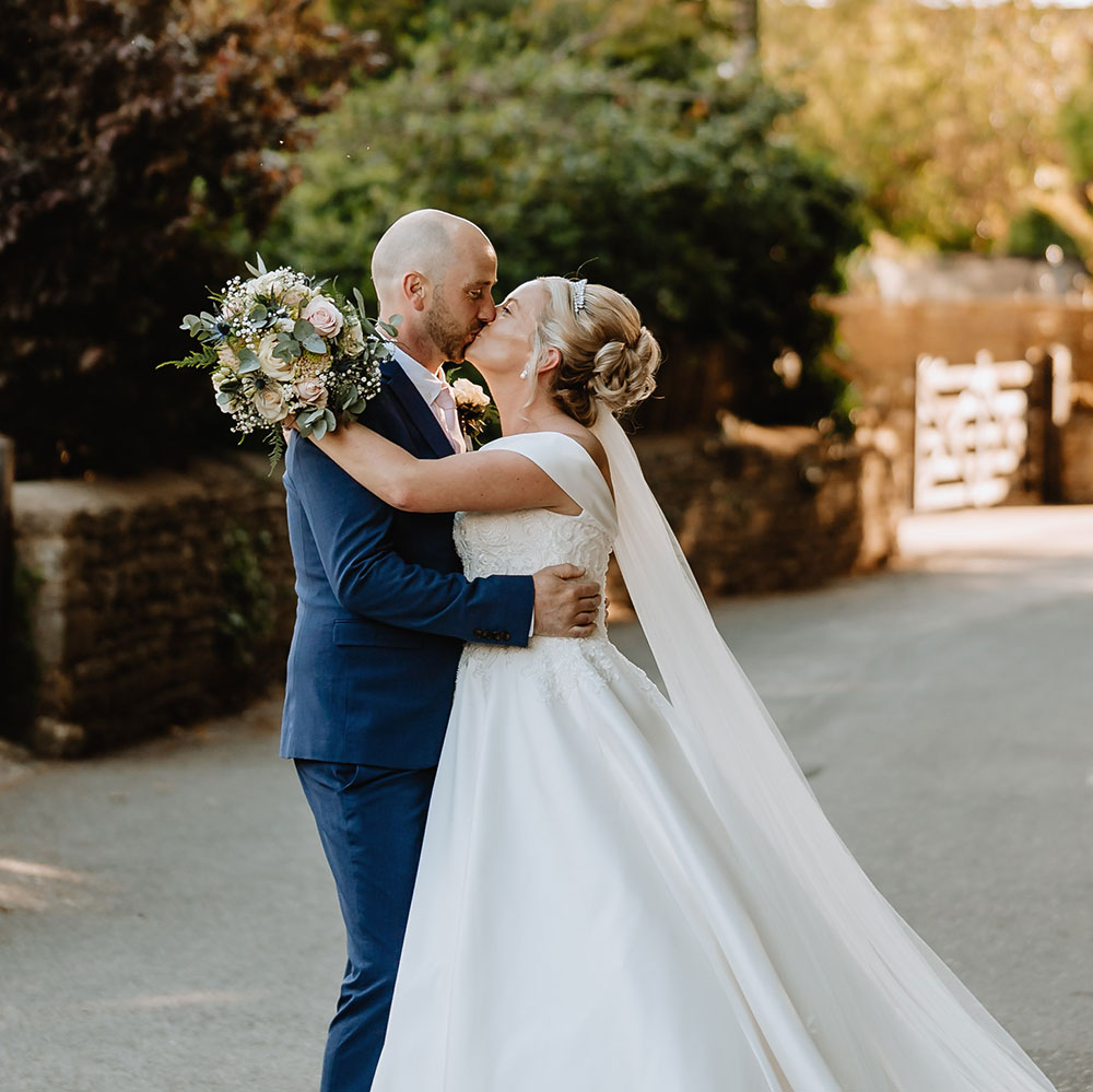 Bride and groom kissing on a street