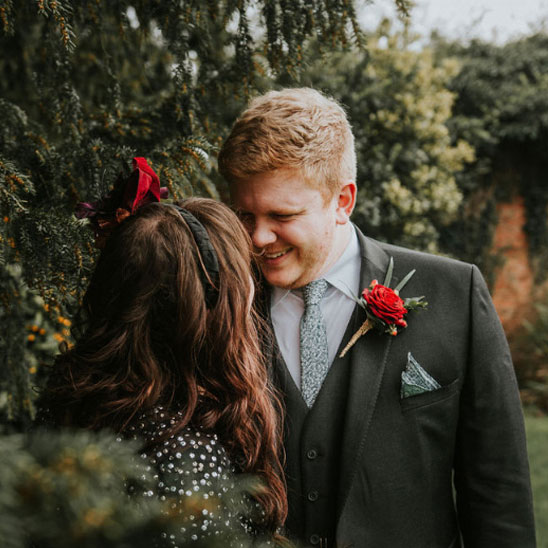 close up of the bride and groom showing them leaning in for a kiss in the garden