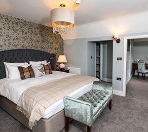 super king bed with a pale blue velvet futon in a feature room