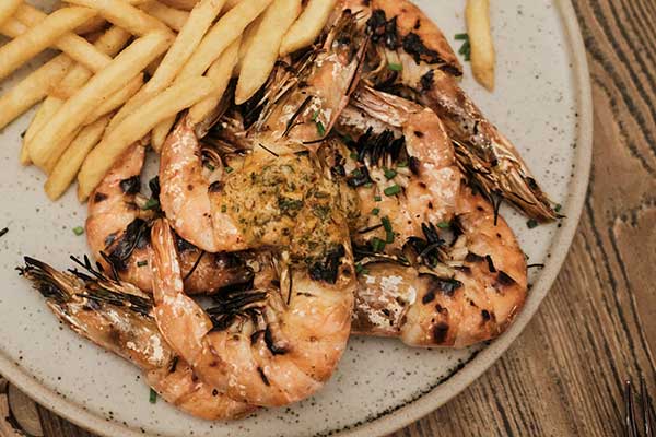 Close up of prawns cooked on the grill with chips