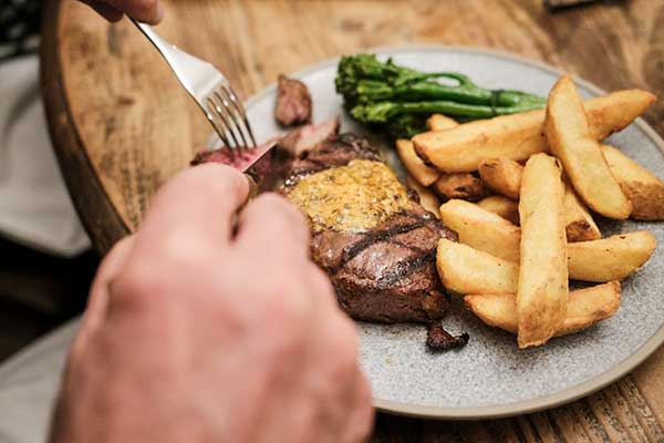 a plate of steak and chips with sauce at Grill night