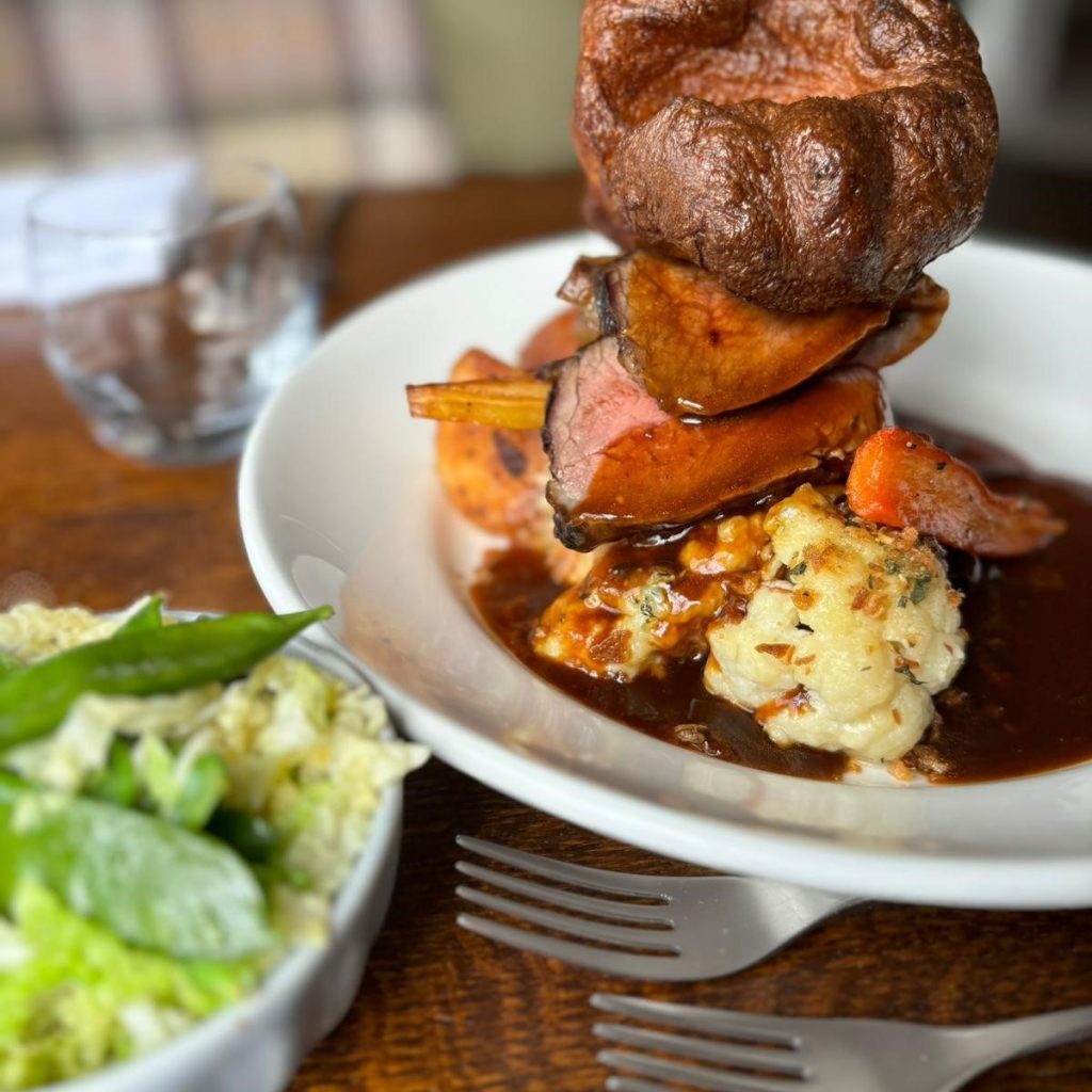 Plate of roast beef Sunday lunch with seasonal veg, Yorkshire pudding and gravy