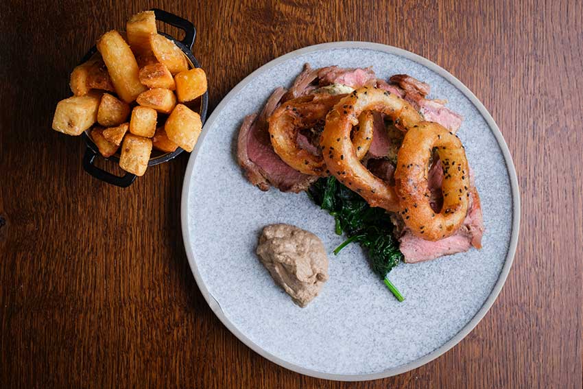 Sirloin beef with chunky chips, onion rings and mushroom puree in the garden restaurant