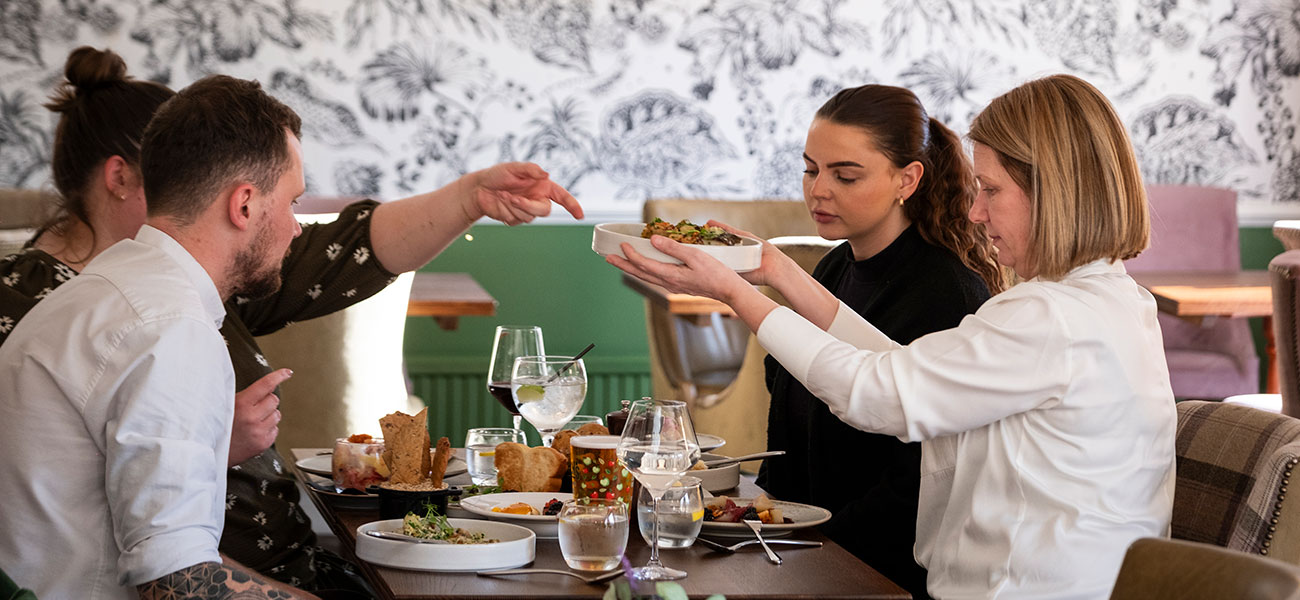 Group of 4 people eating a meal in the garden restaurant