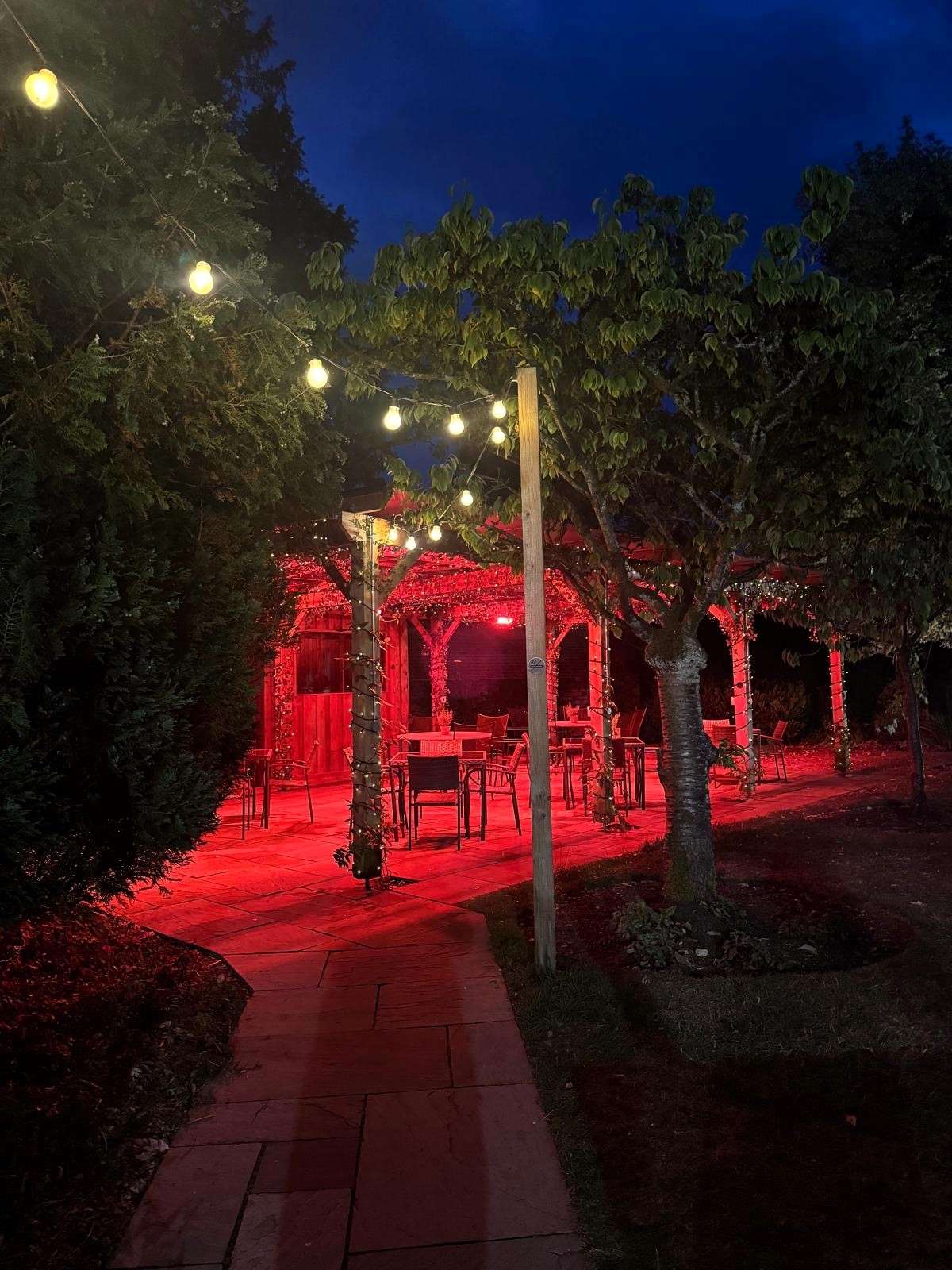 Pergola at night time with heaters on and string lights