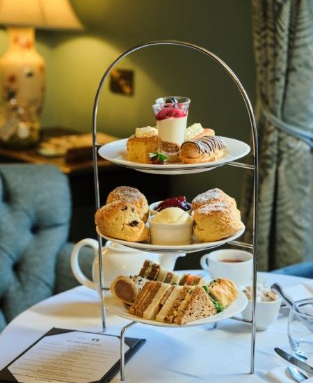 Afternoon tea stand laid out on a table with a selection of desserts and sandwiches