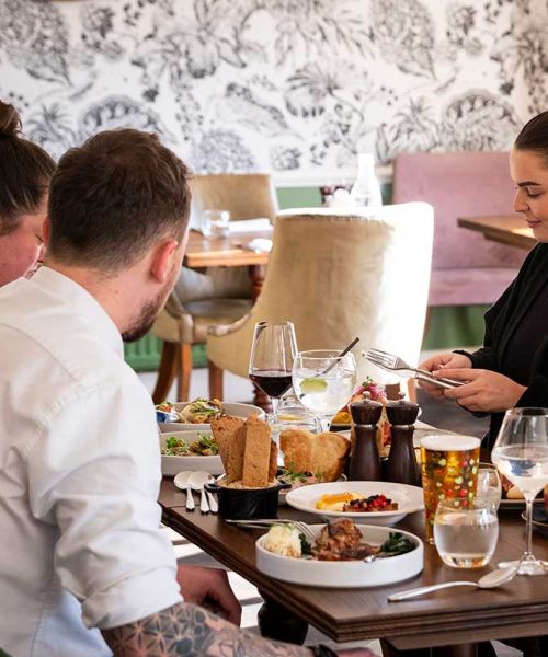 Group of people eating a meal in the garden restaurant