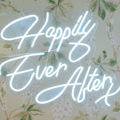 Neon happily ever after sign on the wall at a wedding