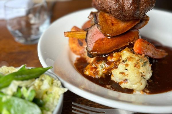 Plate of roast beef Sunday lunch with seasonal veg, Yorkshire pudding and gravy