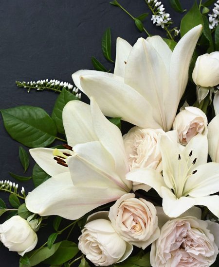 White lillies and roses on a dark background