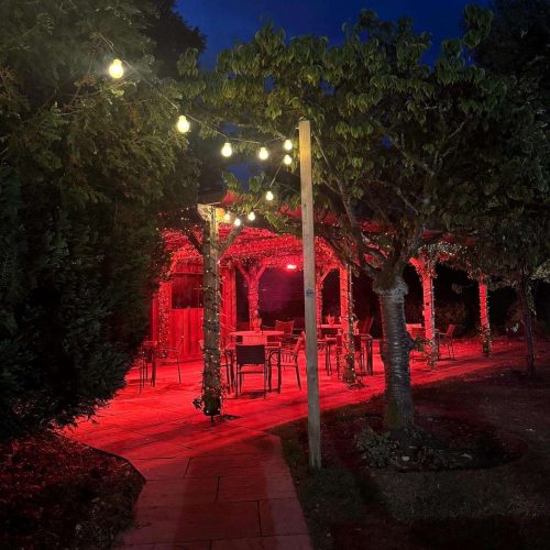 Pergola at night time with heaters on and string lights