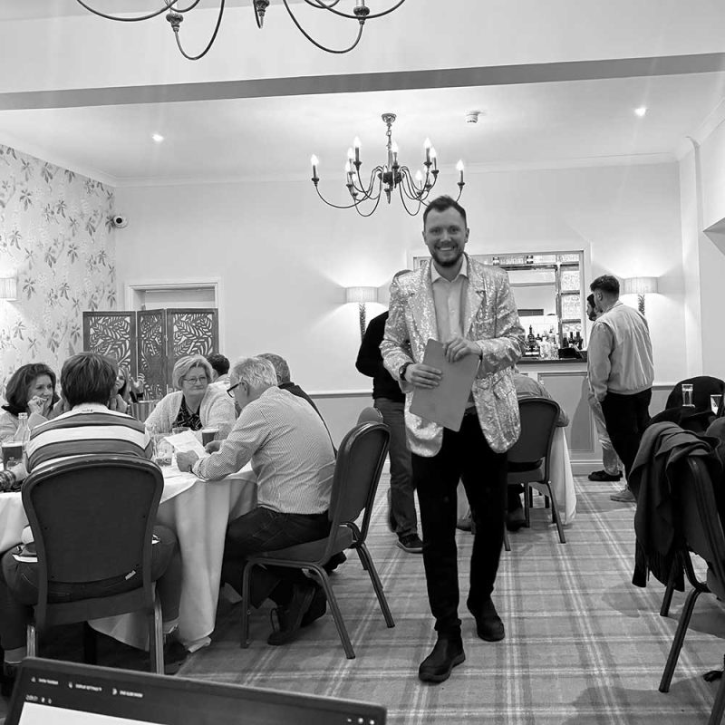 Quiz master in a sparkly jacket ready to start the quiz